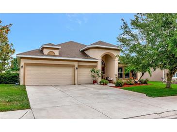 Charming single-story home with a three-car garage and lush landscaping, offering curb appeal at 11324 77Th E St, Parrish, FL 34219