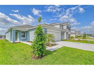 Beautiful, contemporary home with well manicured lawn and bright blue paint at 13125 Bayberry Way, Parrish, FL 34219