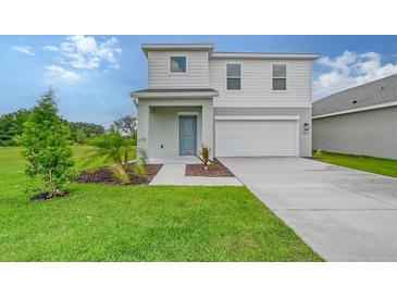 Charming two-story home featuring a well-manicured lawn and a welcoming blue front door at 13129 Bayberry Way, Parrish, FL 34219
