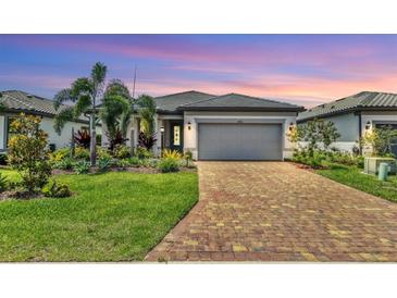 Charming one-story home with a brick driveway and lush, mature landscaping at 17910 Waterville Pl, Lakewood Ranch, FL 34202