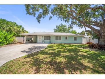Charming single-story home with a well-manicured lawn and mature trees at 2275 Clematis St, Sarasota, FL 34239