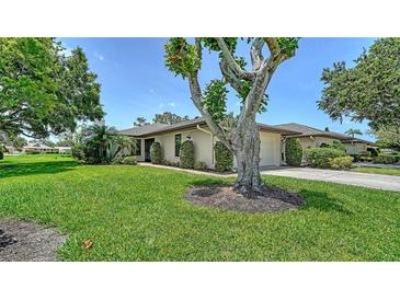 Charming single-story home featuring a well-manicured lawn and a mature tree, offering curb appeal and shade at 3734 Ballantrae Dr # 19D, Sarasota, FL 34238
