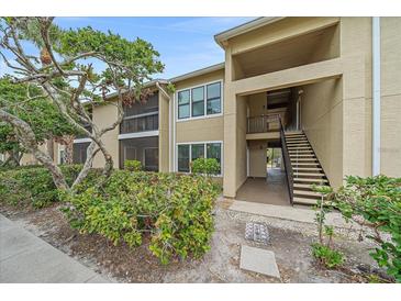 Tan condo building with a combination of screened balconies and stairwell access for upper levels at 4057 Crockers Lake Blvd # 15, Sarasota, FL 34238
