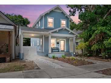 Charming blue two-story home with a welcoming front porch and a convenient carport at 412 E Amelia Ave, Tampa, FL 33602