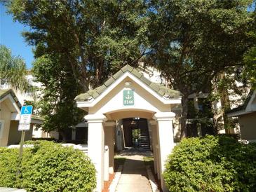 Inviting entrance to the building featuring beautiful landscaping and shaded walkway for residents and guests at 5146 Northridge Rd # 310, Sarasota, FL 34238
