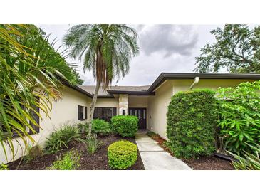 Inviting single-story home with lush landscaping and a stone-accented entryway at 6107 Misty Oaks St, Sarasota, FL 34243