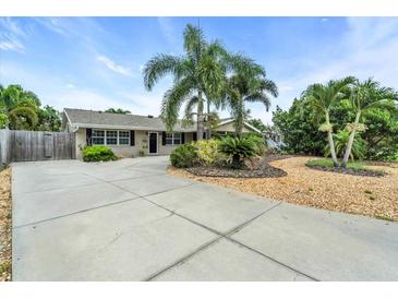 Charming single-story home with a spacious driveway, well-kept lawn, and beautiful palm trees at 6731 Washington Pl, Bradenton, FL 34207