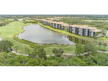 Beautiful aerial view of condominiums overlooking a golf course and lake, offering serene waterfront and golf views at 7005 River Hammock Dr # 303, Bradenton, FL 34212