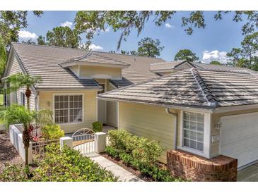 Charming single-story home with tile roof, landscaped front yard, and inviting walkway, blending beauty and functionality at 7617 Whitebridge Gln, University Park, FL 34201