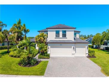 Beautiful two-story home with a three car garage, tropical landscaping, and a brick paver driveway at 826 Honeyflower Loop, Bradenton, FL 34212
