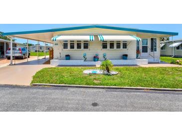 Charming home with awnings, well-kept lawn, carport and front landscaping at 830 Trento Dr, Venice, FL 34285
