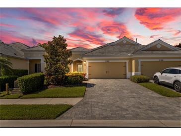 Inviting home featuring manicured landscaping, a paver driveway, and an attached two-car garage at 2070 Crystal Lake Trl, Bradenton, FL 34211