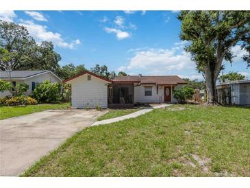 Quaint single-story home featuring a red door and a classic concrete driveway at 2558 Hawthorne St, Sarasota, FL 34239