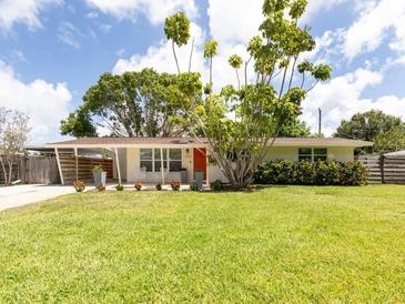 Charming single-story home featuring a well-manicured lawn and colorful landscaping at 2933 Michigan St, Sarasota, FL 34237