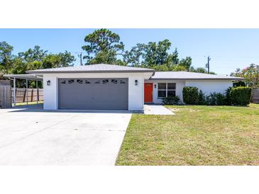 Charming single-story home featuring an attached garage, carport, and an inviting bright orange front door at 3338 Roslyn Rd, Venice, FL 34293