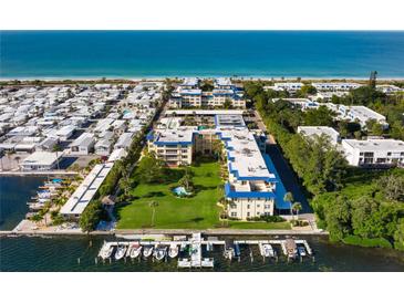 Beautiful aerial view of beachfront condominiums with boat docks and immaculate landscaping at 3802 Gulf Of Mexico Dr # A205, Longboat Key, FL 34228