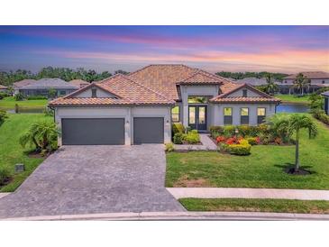 Beautiful single-Gathering home featuring a tile roof, three-car garage, and well-manicured landscaping in a serene community at 4925 Coastal Days Ln, Bradenton, FL 34211
