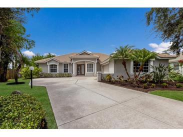Charming single-story home with a well-manicured lawn, mature landscaping, and spacious driveway at 4998 Cedar Oak Way, Sarasota, FL 34233
