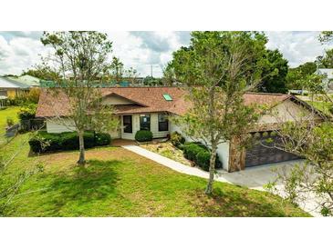 Charming home featuring a well-maintained lawn, mature trees, and a stone-accented two-car garage at 5213 20Th Street E Ct, Bradenton, FL 34203
