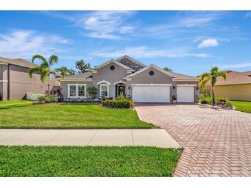 Charming single-story home boasts a well-manicured lawn, brick driveway, and a three-car garage at 5515 69Th E Pl, Ellenton, FL 34222