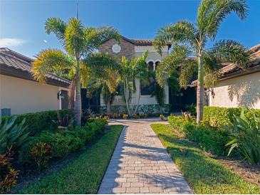 Stunning home featuring lush landscaping, a paver walkway, and a charming stone accent facade at 5604 Palmer Cir # 103, Bradenton, FL 34211