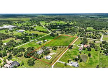 A large parcel of land is ready for development surrounded by lush greenery, homes, and a serene pond at 6875 Myakka Valley Trl, Sarasota, FL 34241