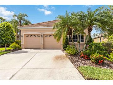 Charming single-story home featuring a two-car garage and tropical landscaping, creating an inviting curb appeal at 7343 Birds Eye Ter, Bradenton, FL 34203