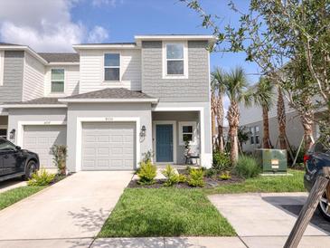 Charming two-story home featuring a one car garage, nicely landscaped front yard and a welcoming blue front door at 8733 Winter Breeze Way, Sarasota, FL 34241