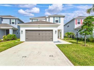 Beautiful two-story home featuring a neutral color scheme, lush lawn, and a two-car garage at 9040 Tequila Sunrise Dr, Sarasota, FL 34241