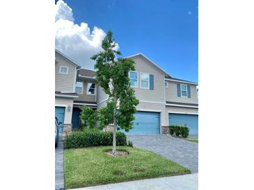 Charming townhome with a blue garage door, stone accents, and well-maintained landscaping at 11613 Woodleaf Dr, Lakewood Ranch, FL 34211