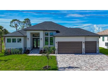 Stunning single-story home featuring a three-car garage, paved driveway, and beautifully landscaped front yard at 1167 Boundary Blvd, Rotonda West, FL 33947