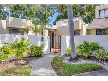 Inviting home featuring gated courtyard, lush tropical landscaping and a curved walkway to the entrance at 2383 Lakeside Mews # D3, Sarasota, FL 34235