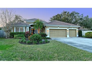 Beautiful home featuring a three-car garage, a well-manicured lawn, and a tile roof at 5401 Oak Grove Ct, Sarasota, FL 34233