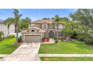 Charming two-story home with a manicured lawn, mature trees, and a two-car garage at 6043 44Th E Ct, Bradenton, FL 34203