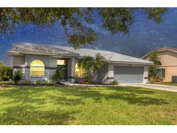 Charming single-story home featuring a well-maintained lawn and inviting curb appeal with beautiful landscaping at 6929 Stetson Street Cir, Sarasota, FL 34243