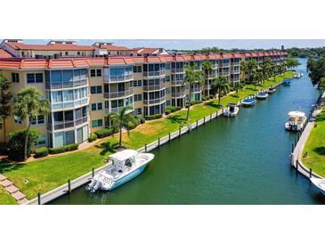 Waterfront condos with a boat slip, featuring lush landscaping and direct access to beautiful waterways at 1300 N Portofino Dr # 103, Sarasota, FL 34242