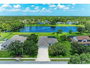 Beautiful aerial view of home with a spacious yard and a serene lake in the backyard at 208 147Th Ne St, Bradenton, FL 34212