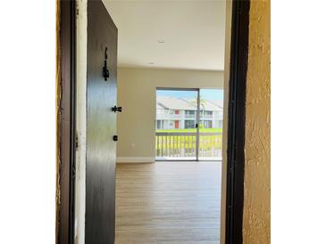 Bright living room with wood flooring, and a sliding glass door leading to an outdoor view at 2636 Hidden Lake N Dr # G, Sarasota, FL 34237
