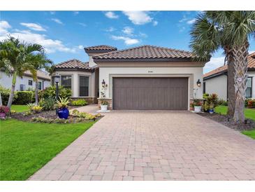 Beautiful front exterior of home with a tile roof, two-car garage, and beautifully landscaped front yard at 4540 Terrazza Ct, Bradenton, FL 34211