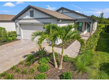 Charming single-story home with a two-car garage, manicured lawn, and inviting front entrance at 6563 Silverstar Dr, Sarasota, FL 34240