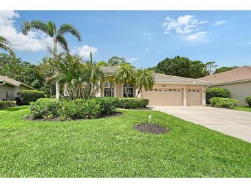 Charming home featuring a well-manicured lawn, lush landscaping, and a spacious three-car garage at 7464 Ridge Rd, Sarasota, FL 34238