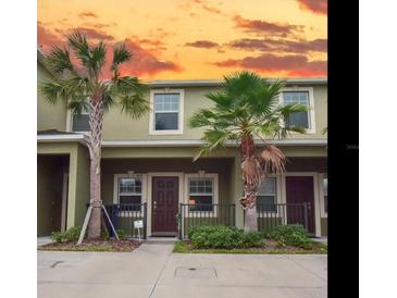 Townhome exterior showcasing tropical landscaping including palm trees at 1426 Harbour Blue St, Ruskin, FL 33570