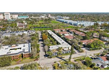 An aerial view shows the property nestled in a vibrant community with lush greenery and convenient parking at 2155 Wood St # A26, Sarasota, FL 34237