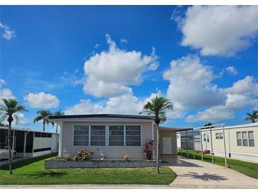 Charming single-story home featuring a well-maintained lawn, mature palm trees, and a convenient covered parking area at 3224 Aspen Ter, Sarasota, FL 34237