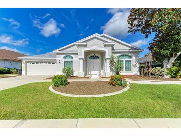 Charming single-story home with a well-manicured lawn, landscaped garden beds, and attached two-car garage at 4426 Useppa Dr, Bradenton, FL 34203