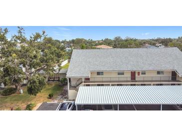 Exterior view of condo building featuring covered parking, and a well maintained landscaped yard at 516 Parkdale Mews # 516, Venice, FL 34285