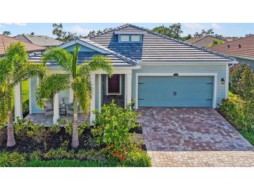 Beautiful single Gathering home with lush landscaping and a brick driveway leading to the two car garage at 5750 Long Shore Loop, Sarasota, FL 34238