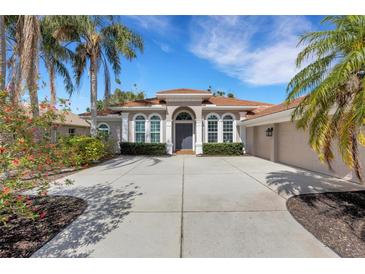 Charming single-story home with a spacious driveway, lush landscaping, and a terracotta tile roof at 8102 Waterview Blvd, Lakewood Ranch, FL 34202