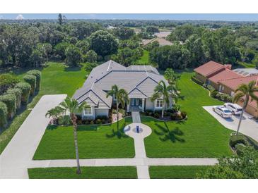Stunning aerial view of a landscaped property featuring a well-manicured lawn and beautiful surroundings at 8924 Misty Creek Dr, Sarasota, FL 34241