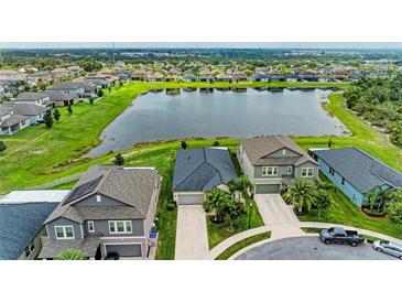 Beautiful aerial view of homes and a scenic lake in a well-maintained, vibrant community at 10609 Great Cormorant Dr, Riverview, FL 33579